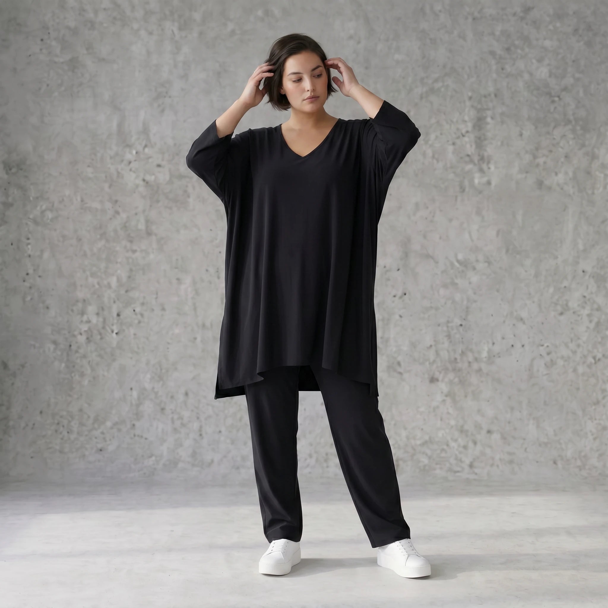 Schwarzes A-Form Shirt aus Travellermaterial Rundhals Dreiviertelärmeln und Zipfelsaum