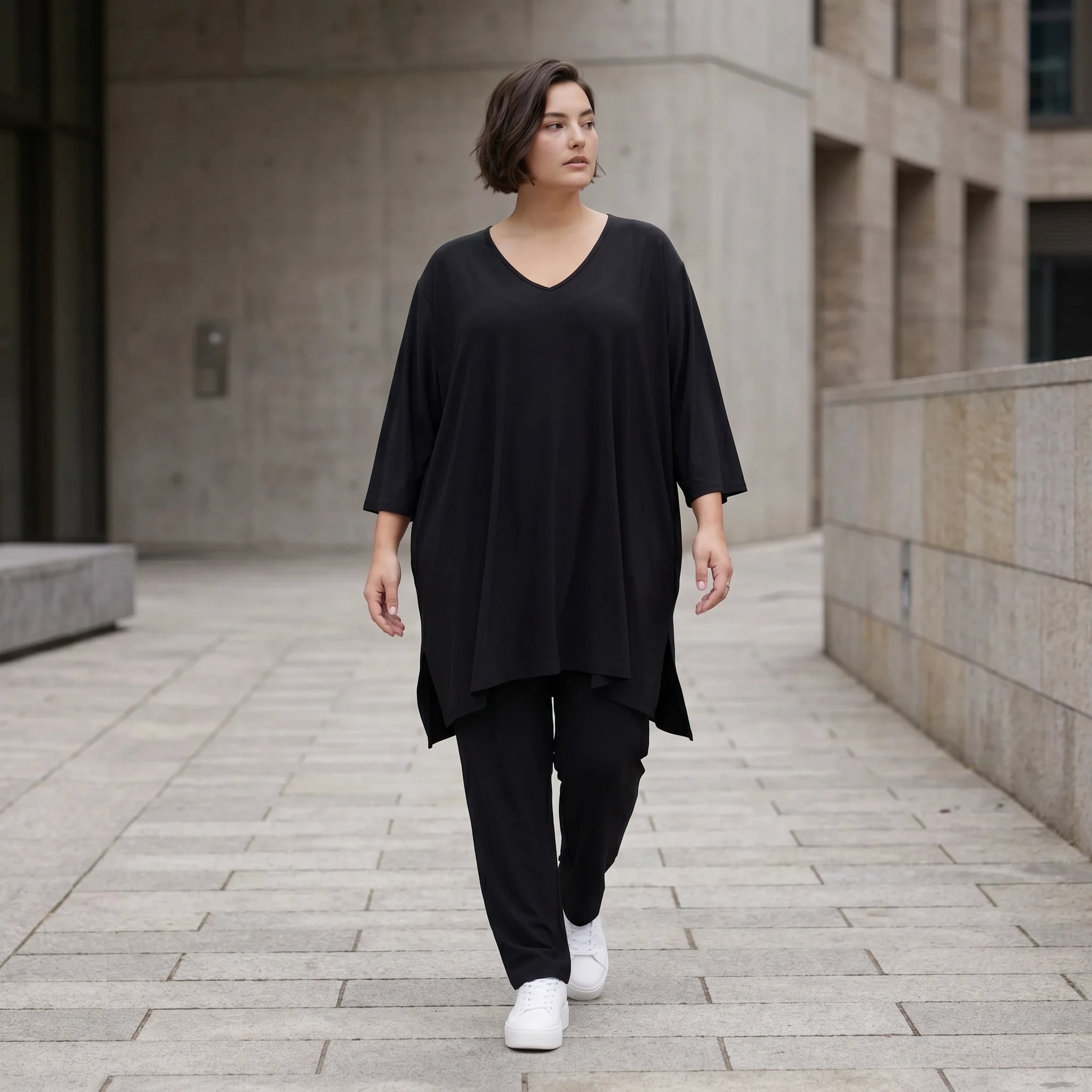 Schwarzes A-Form Shirt aus Travellermaterial Rundhals Dreiviertelärmeln und Zipfelsaum