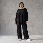 Fließendes Shirt aus schwarzem Jersey mit femininer Silhouette und leicht zipfeligem Saum