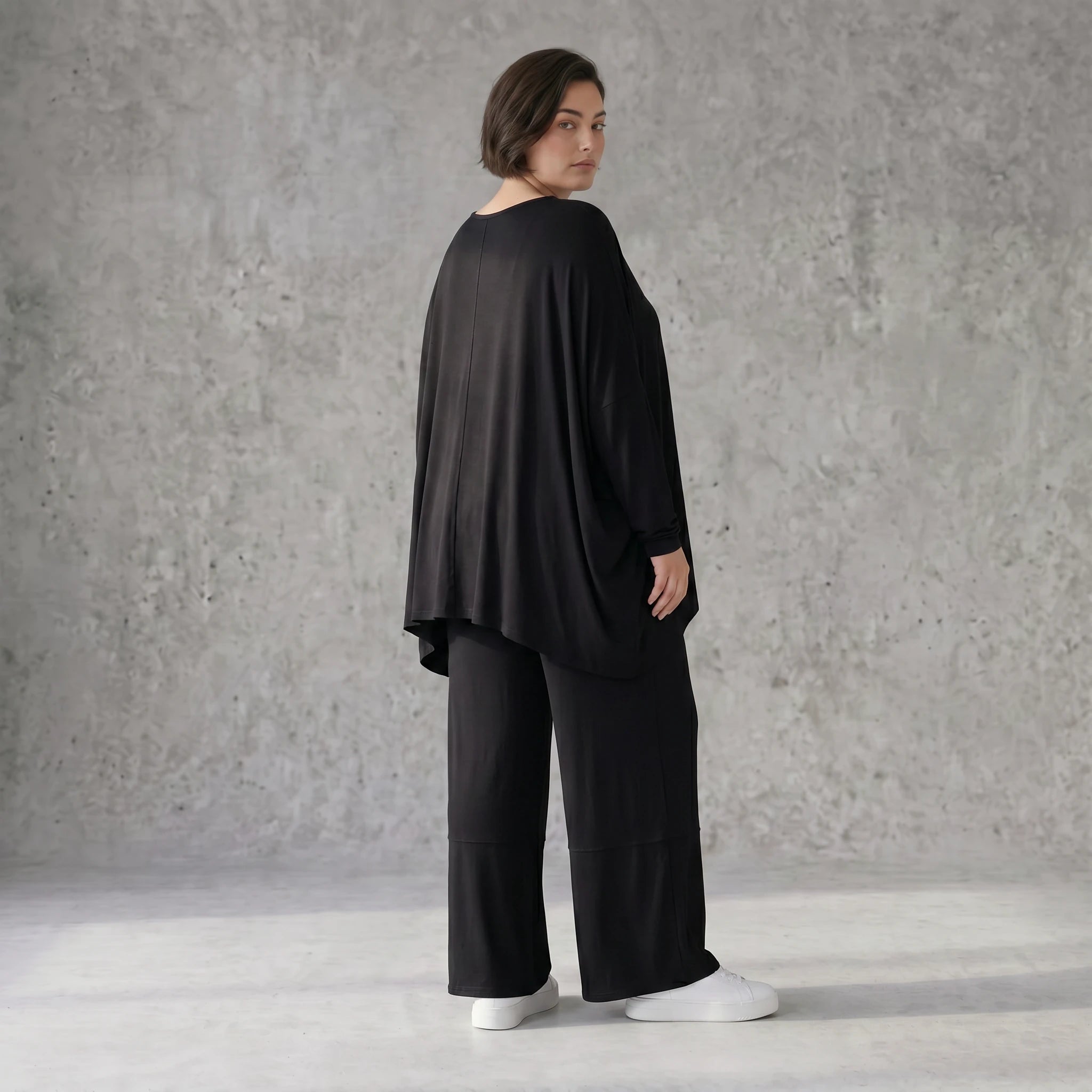 Fließendes Shirt aus schwarzem Jersey mit femininer Silhouette und leicht zipfeligem Saum
