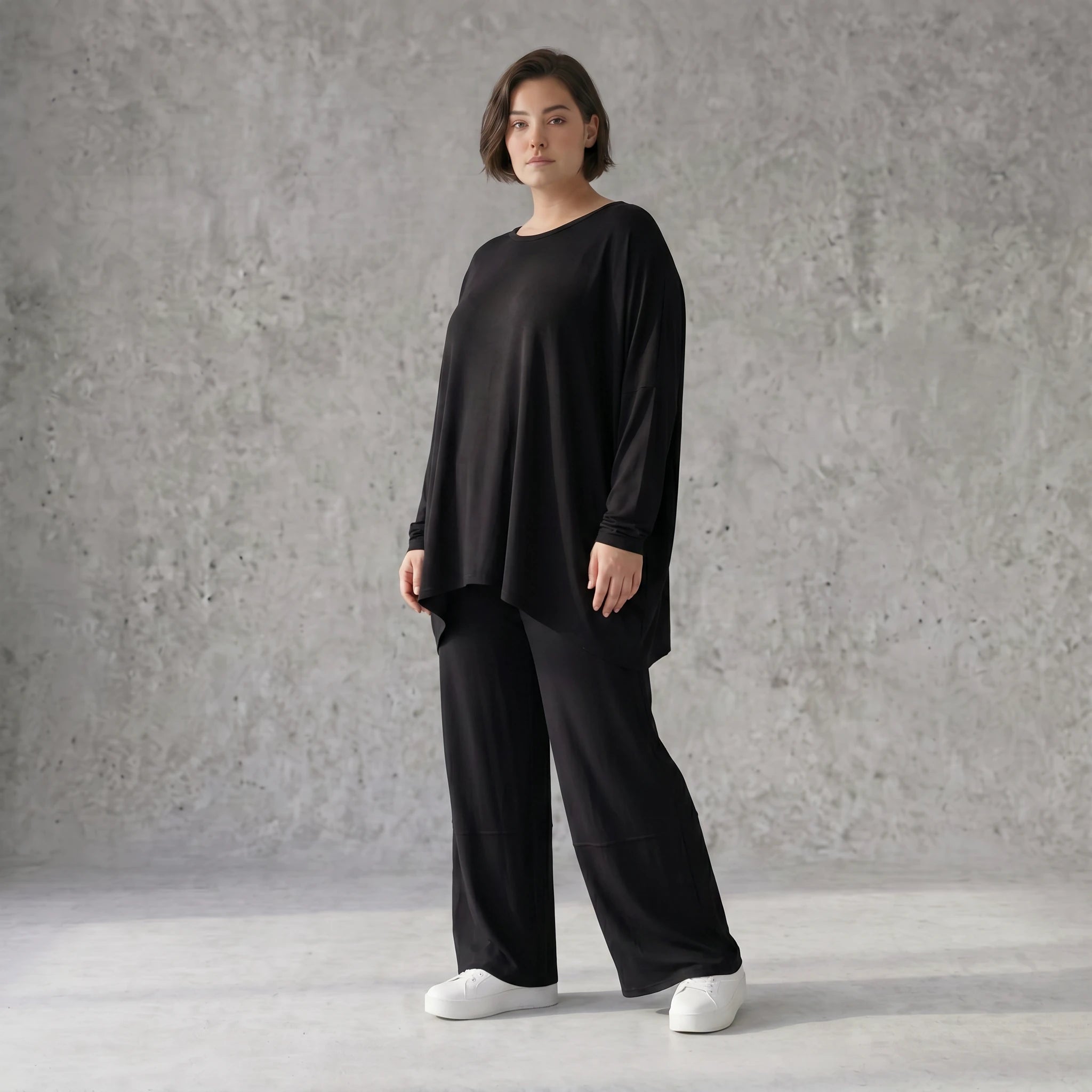 Fließendes Shirt aus schwarzem Jersey mit femininer Silhouette und leicht zipfeligem Saum