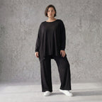 Fließendes Shirt aus schwarzem Jersey mit femininer Silhouette und leicht zipfeligem Saum