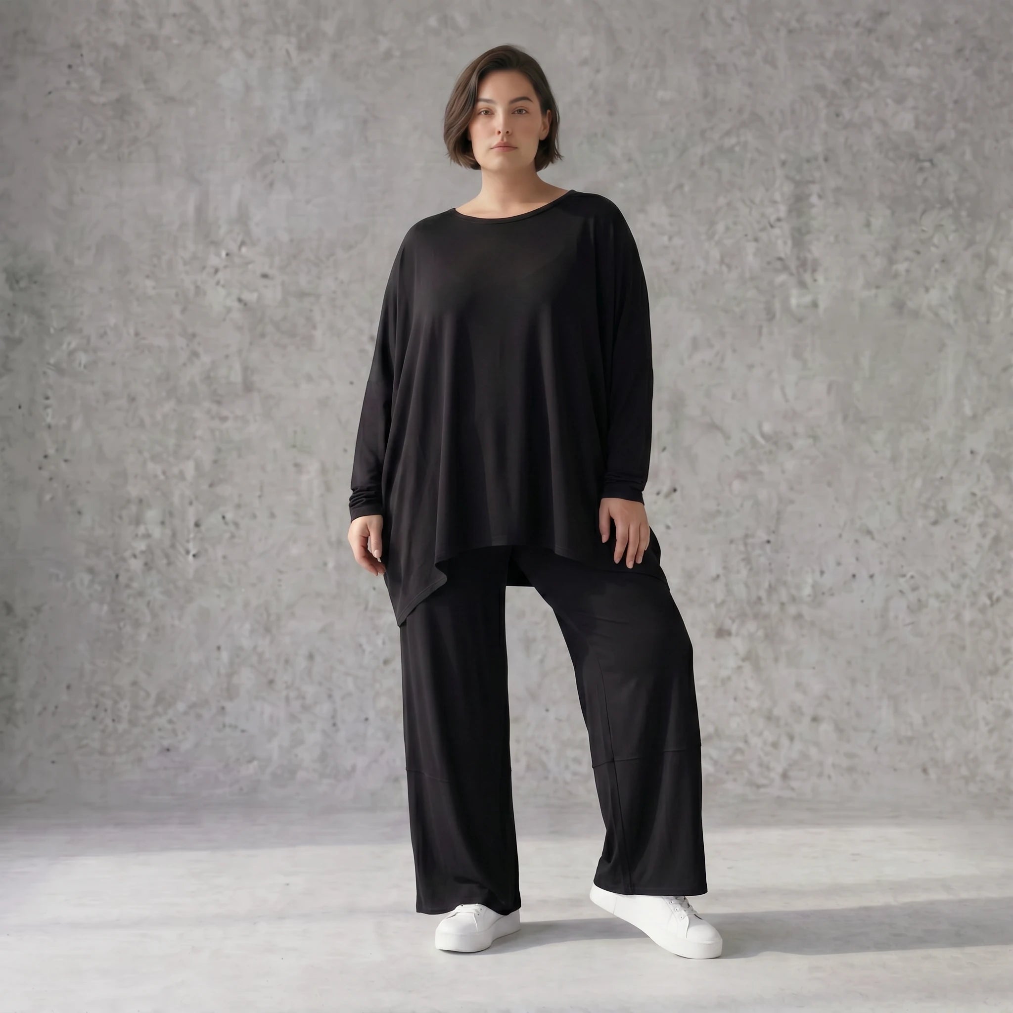 Fließendes Shirt aus schwarzem Jersey mit femininer Silhouette und leicht zipfeligem Saum