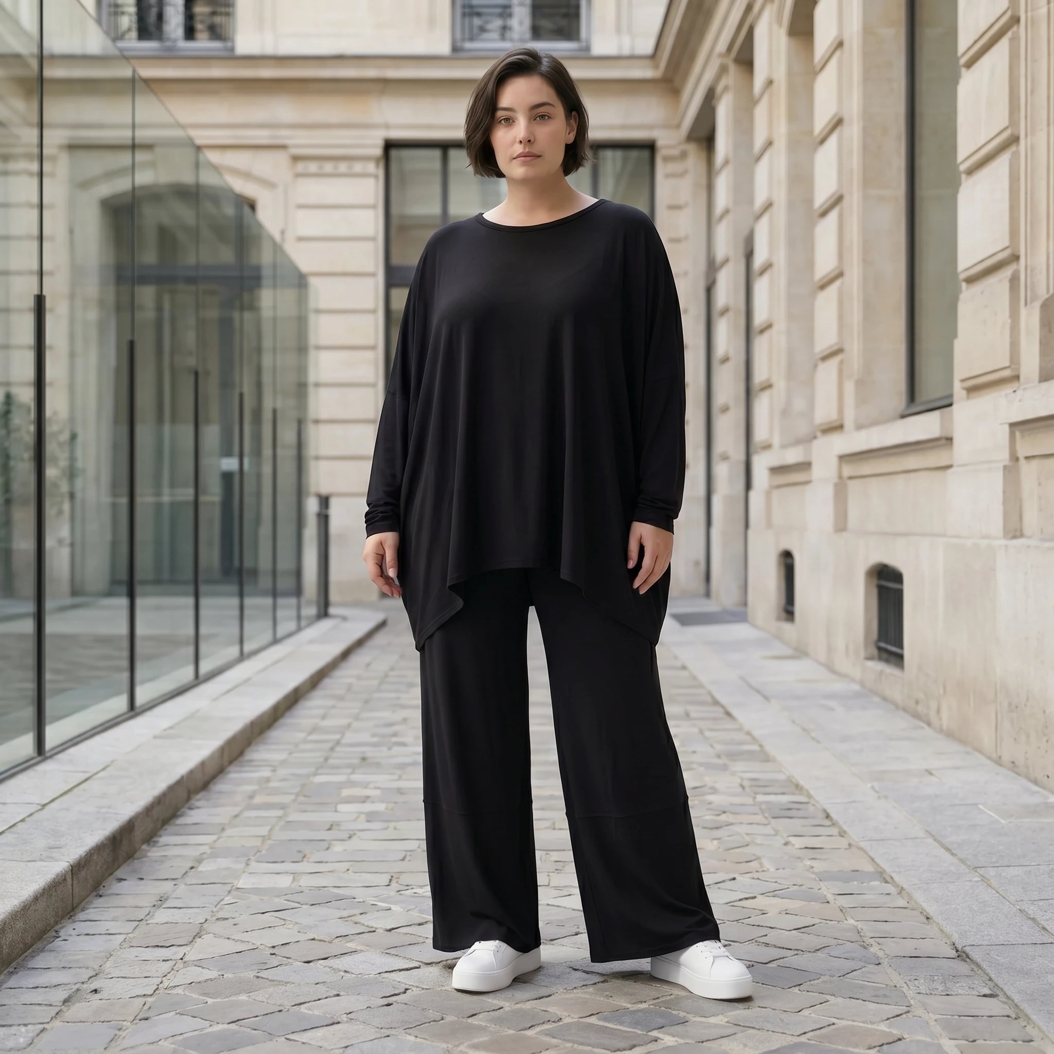 Fließendes Shirt aus schwarzem Jersey mit femininer Silhouette und leicht zipfeligem Saum