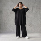 Fließendes Glockenshirt in tiefem Schwarz mit 3/4-Arm Rundhalsausschnitt und Nahttaschen