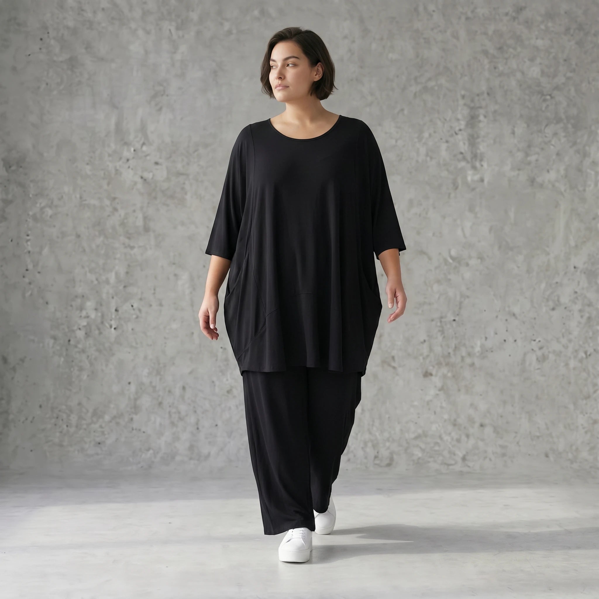 Fließendes Glockenshirt in tiefem Schwarz mit 3/4-Arm Rundhalsausschnitt und Nahttaschen