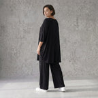 Fließendes Glockenshirt in tiefem Schwarz mit 3/4-Arm Rundhalsausschnitt und Nahttaschen