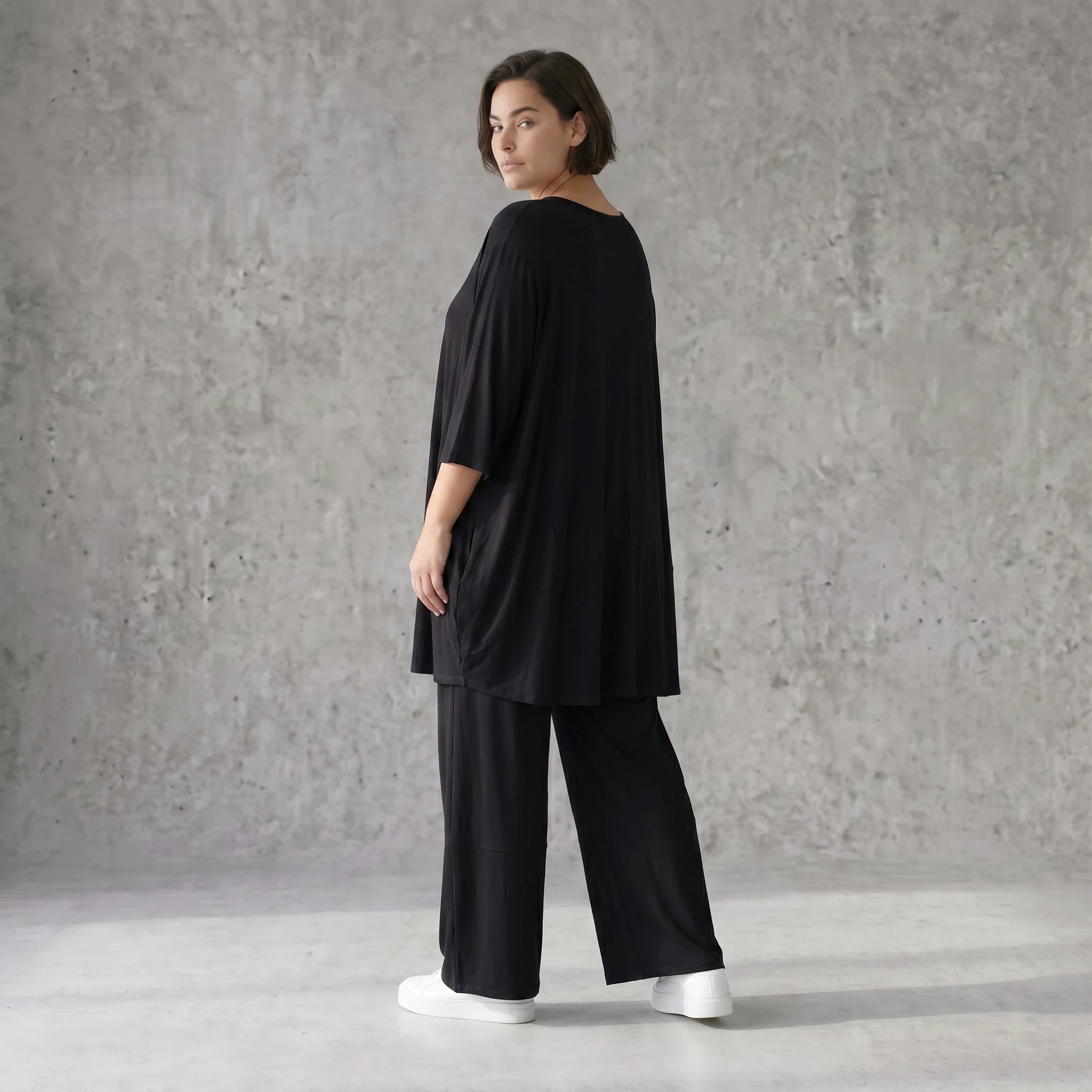 Fließendes Glockenshirt in tiefem Schwarz mit 3/4-Arm Rundhalsausschnitt und Nahttaschen