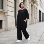 Fließendes Glockenshirt in tiefem Schwarz mit 3/4-Arm Rundhalsausschnitt und Nahttaschen