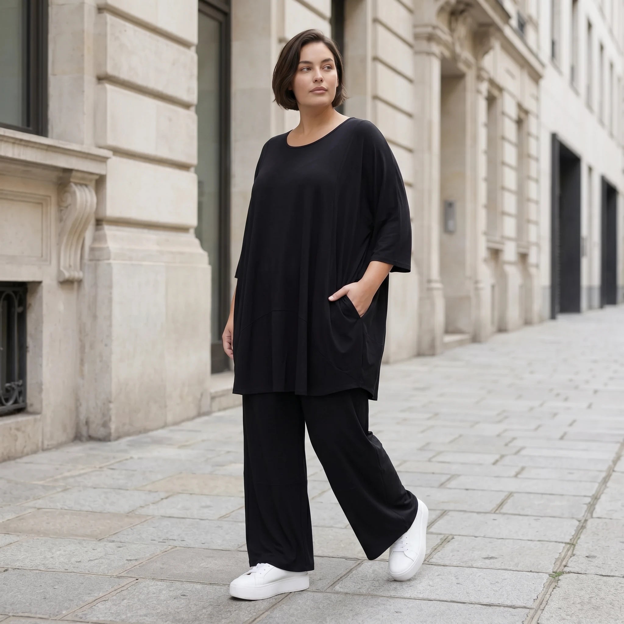 Fließendes Glockenshirt in tiefem Schwarz mit 3/4-Arm Rundhalsausschnitt und Nahttaschen