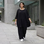Fließendes Glockenshirt in tiefem Schwarz mit 3/4-Arm Rundhalsausschnitt und Nahttaschen