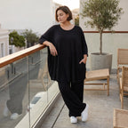 Fließendes Glockenshirt in tiefem Schwarz mit 3/4-Arm Rundhalsausschnitt und Nahttaschen