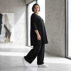 Fließendes Glockenshirt in tiefem Schwarz mit 3/4-Arm Rundhalsausschnitt und Nahttaschen