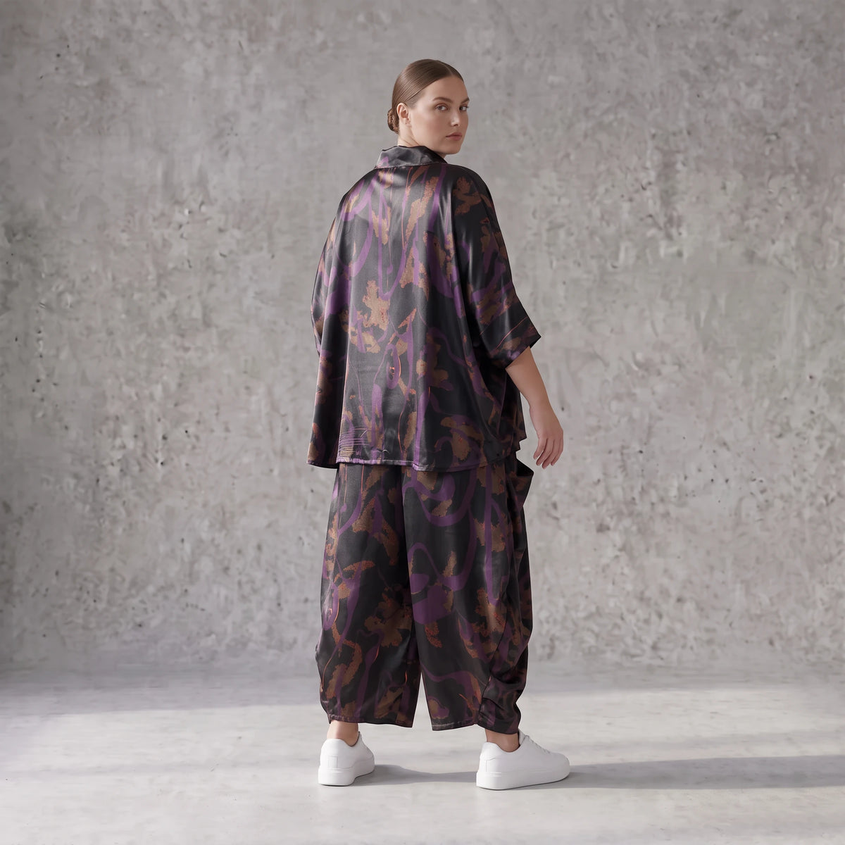 Ballonhose aus Satin in Schwarz/Violett/Braun mit abstraktem Printmuster und Elastikbund