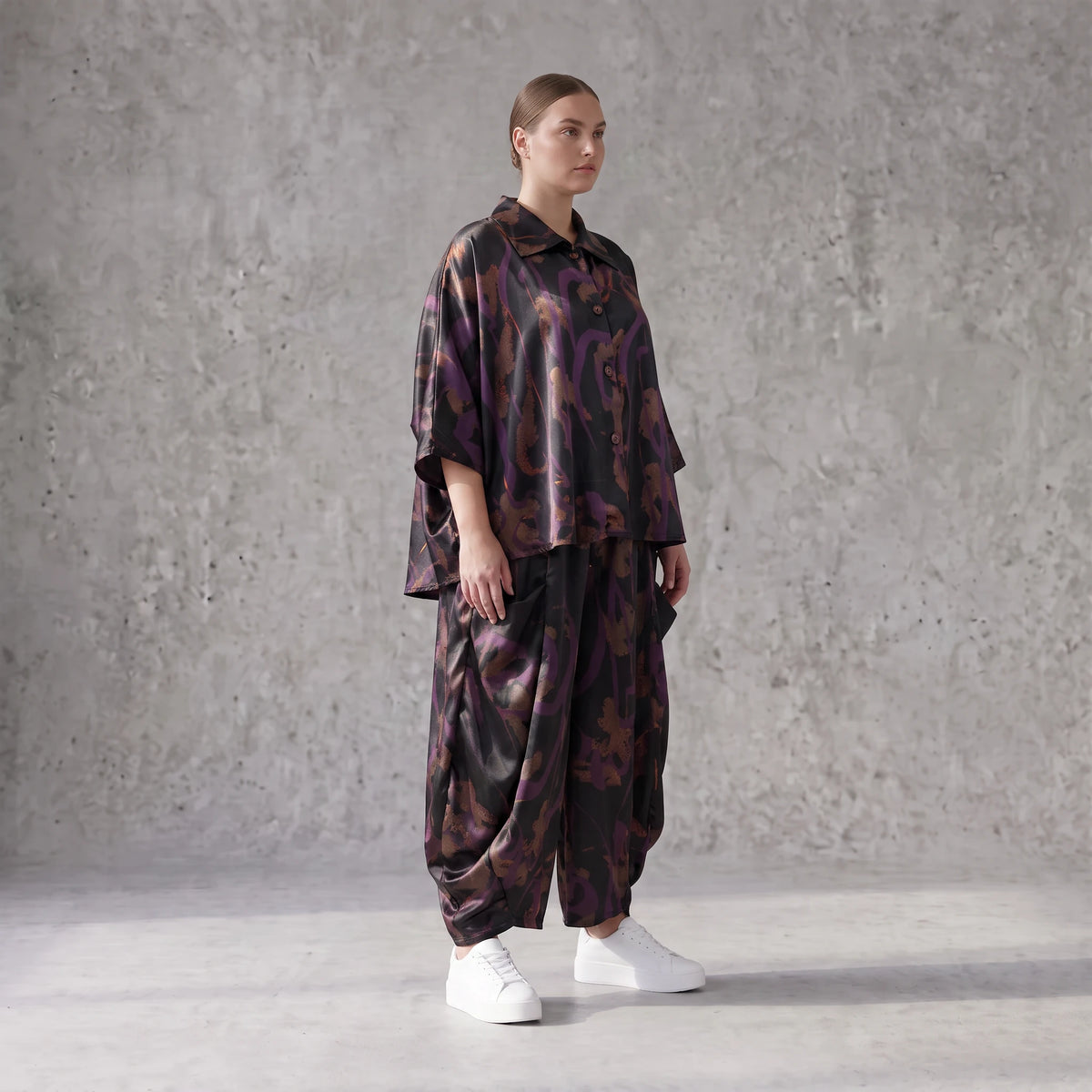 Ballonhose aus Satin in Schwarz/Violett/Braun mit abstraktem Printmuster und Elastikbund