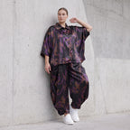 Ballonhose aus Satin in Schwarz/Violett/Braun mit abstraktem Printmuster und Elastikbund