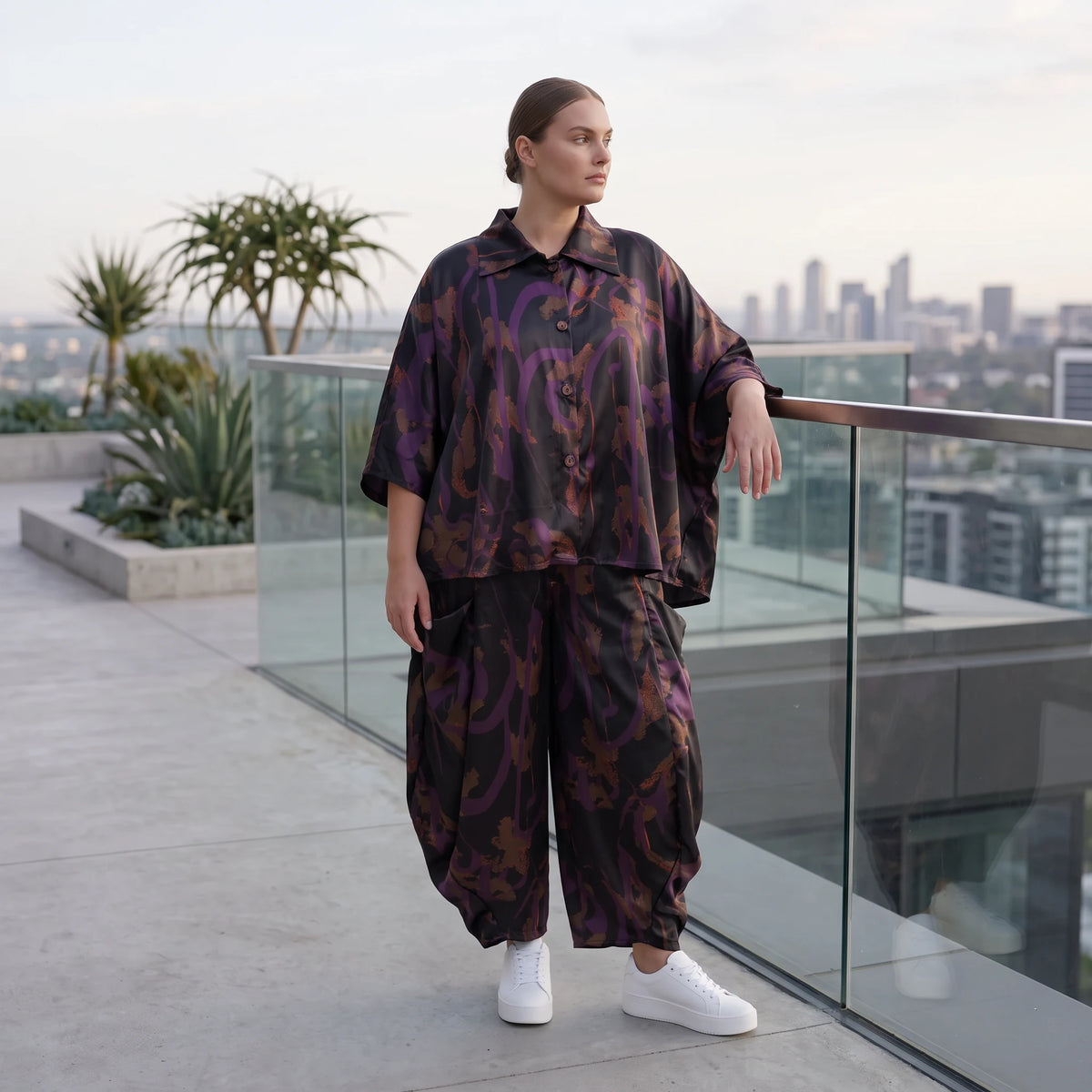 Ballonhose aus Satin in Schwarz/Violett/Braun mit abstraktem Printmuster und Elastikbund