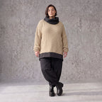 Beiger Strickpullover mit Rollkragen und seitlichen Schlitzen vorne kurz hinten lang