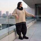 Beiger Strickpullover mit Rollkragen und seitlichen Schlitzen vorne kurz hinten lang