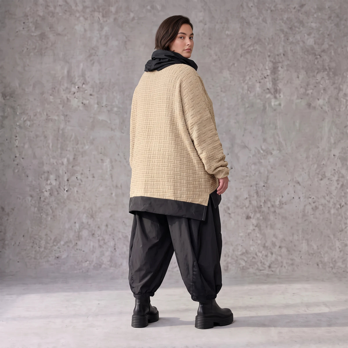 Beiger Strickpullover mit Rollkragen und seitlichen Schlitzen vorne kurz hinten lang