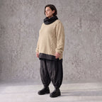Beiger Strickpullover mit Rollkragen und seitlichen Schlitzen vorne kurz hinten lang