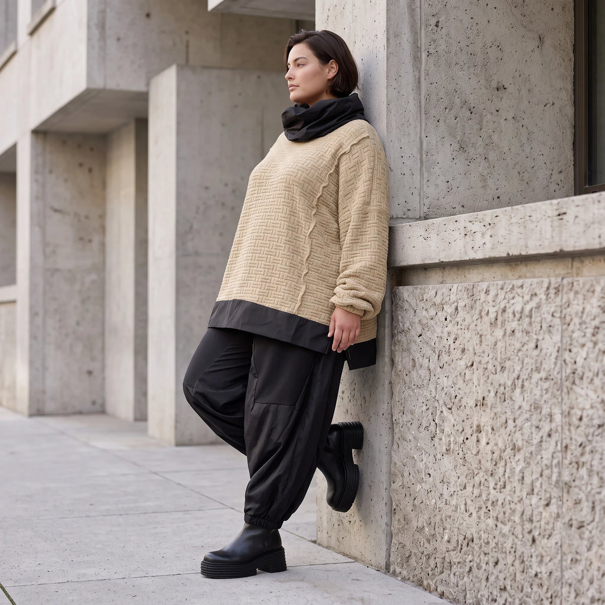 Beiger Strickpullover mit Rollkragen und seitlichen Schlitzen vorne kurz hinten lang