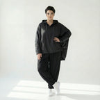 Oversize Ballonjacke in tiefschwarzem Baumwollmemorytaft mit Kapuze Langarm Cutouts