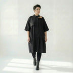 Schwarzes Oversizekleid aus Baumwollpopeline mit Cutoutkragen und asymmetrischem Volant