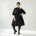 Schwarzes Oversizekleid aus Baumwollpopeline mit Cutoutkragen und asymmetrischem Volant