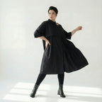 Schwarzes Oversizekleid aus Baumwollpopeline mit Cutoutkragen und asymmetrischem Volant