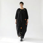 Schwarzes Oversize Kleid mit Neonkordeln asymmetrischer Raffstruktur und weitem Rundhals